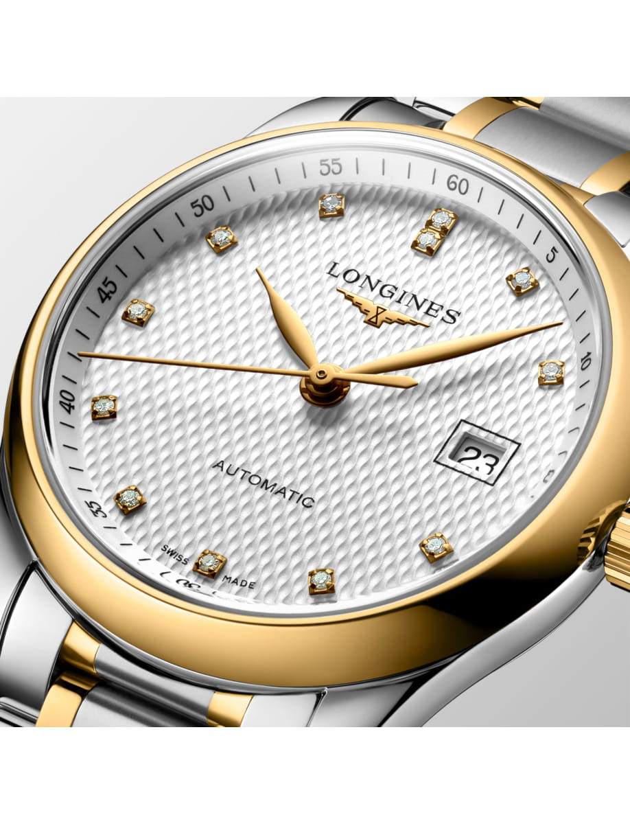 Close-up of a two-tone Longines automatic wristwatch with diamond hour markers and date window at 3 o'clock.