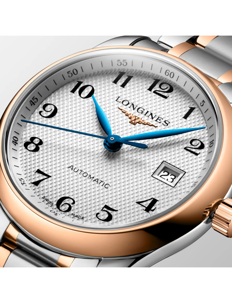 Close-up of a two-tone Longines automatic wristwatch with blue hands and a date window