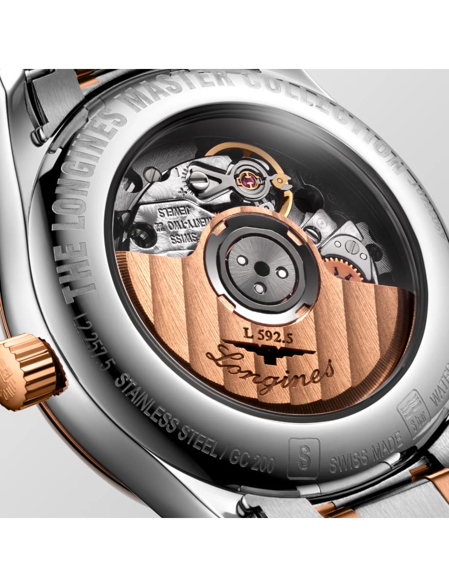 Close-up of a Swiss-made watch movement with copper rotor and gears, engraved Longines on the rotor.