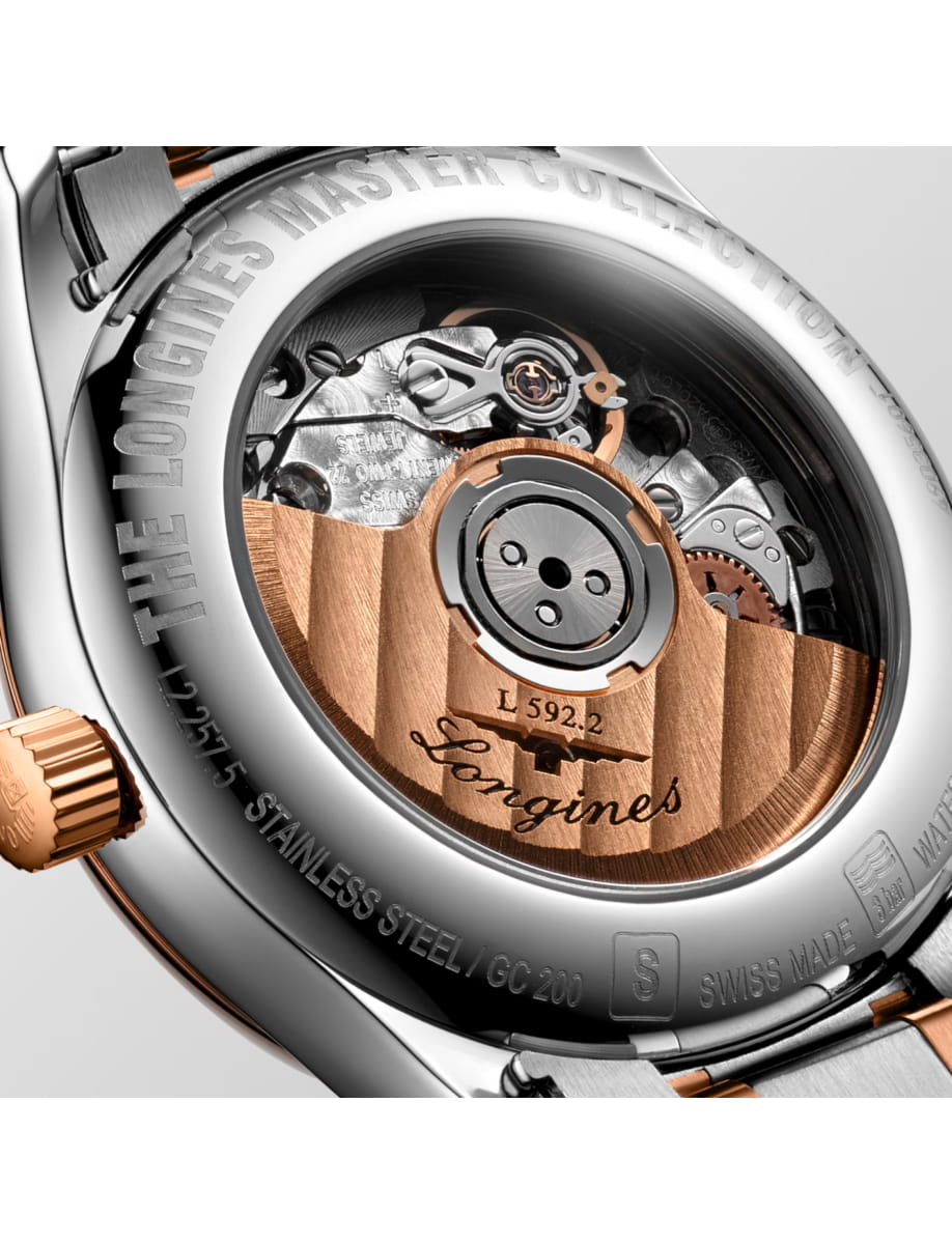 Close-up of a luxury watch case back showing the mechanical movement with a rose-gold rotor and engraved details.