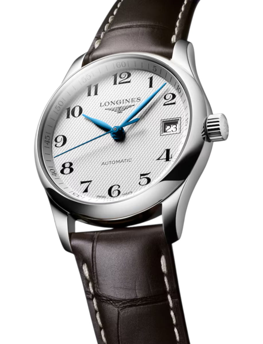 Longines wristwatch with white textured dial, blue hands, date window at 3 o'clock, stainless steel case, brown leather strap.