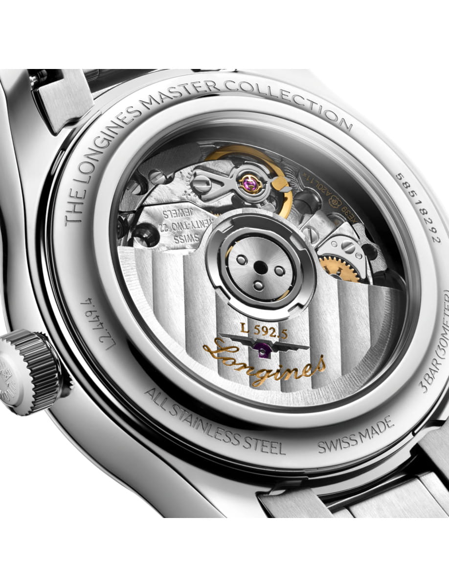 Close-up of a Longines watch movement visible through the transparent case back, with engravings and a purple jewel.