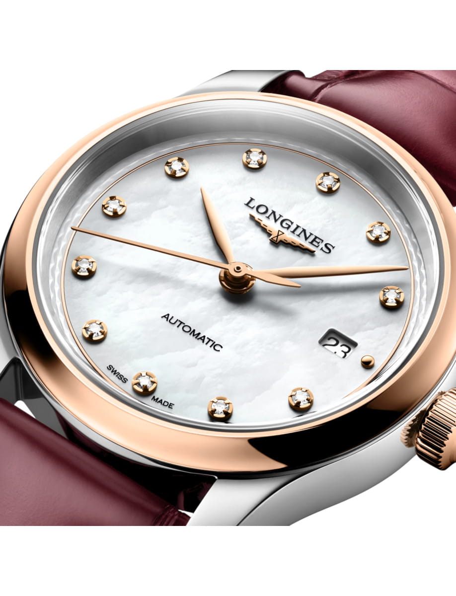 Close-up of a Longines ladies' automatic wristwatch with a pearl-white dial, diamond hour markers, rose-gold bezel, and bordeaux strap with a date window at 3 o'clock.