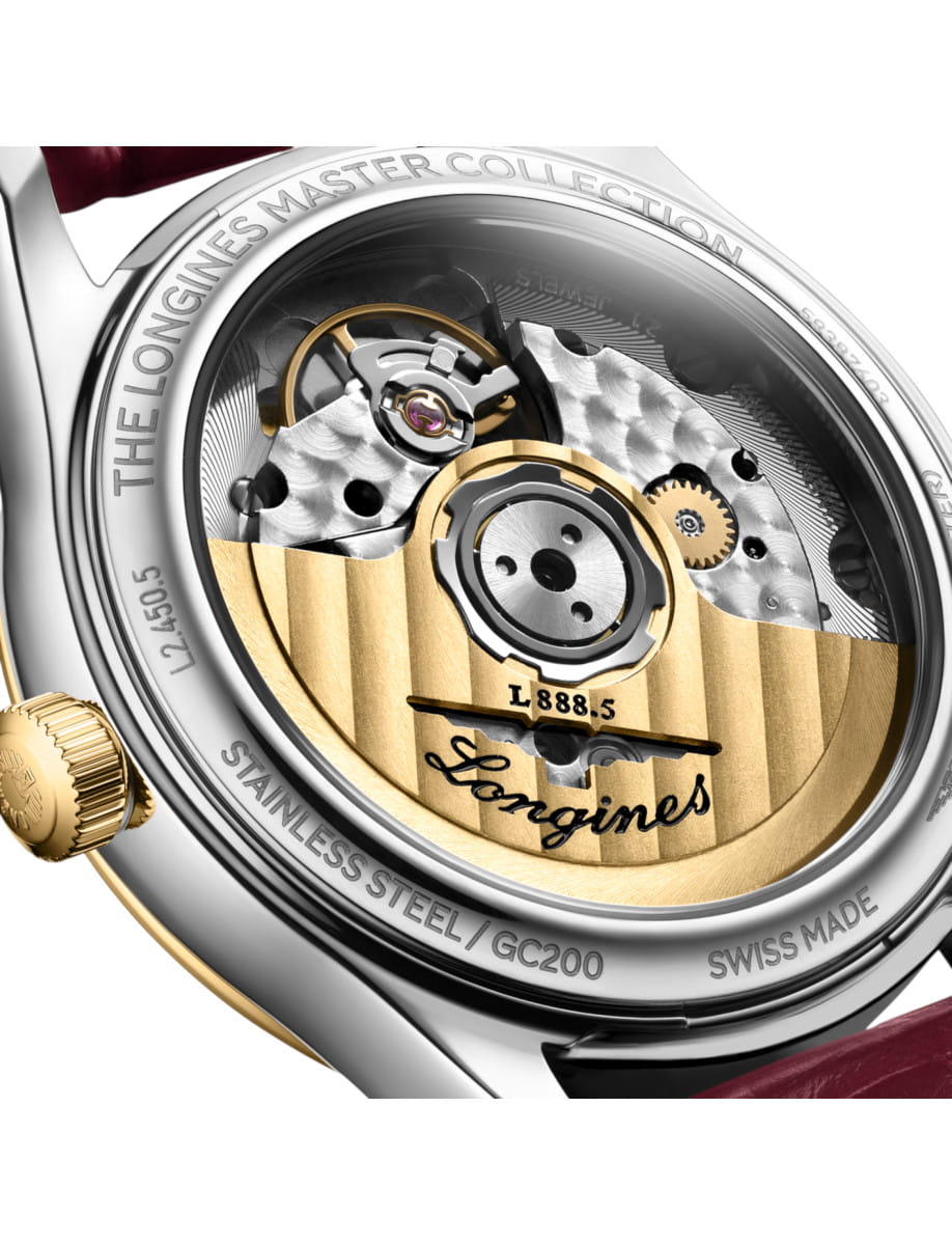 Close-up of a Longines watch movement with a yellow-gold rotor, gears, and 'Longines' engravings visible on the back of the case.