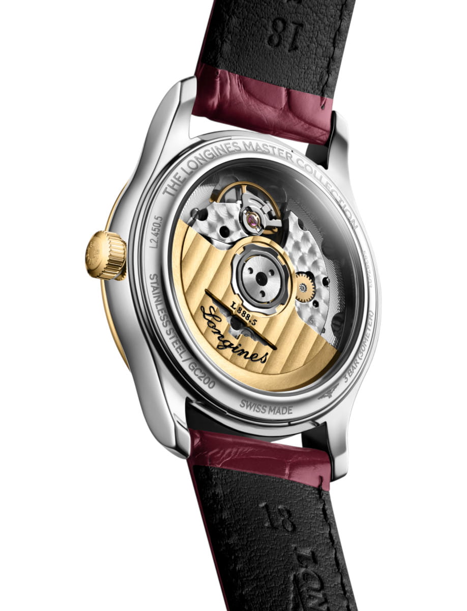 Back view of a Longines watch movement with a yellow-gold rotor, gears, and 'Longines' engravings visible on the back of the case.