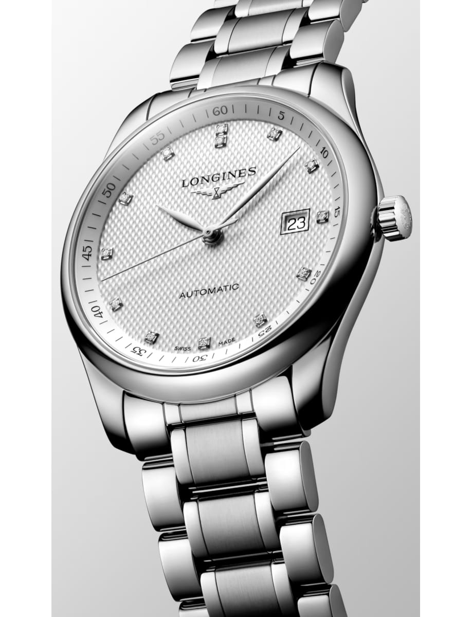 Close-up of a silver Longines automatic wristwatch with a textured dial, diamond hour markers, and date window at 3 o'clock.