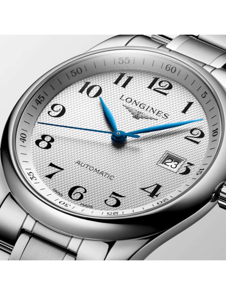 Close-up of a silver Longines wristwatch with blue hands and a date window