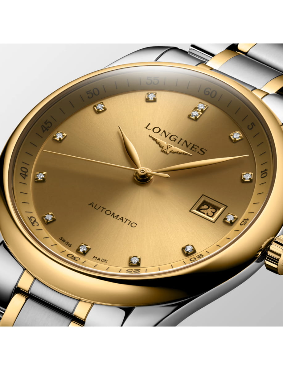 Close-up of a gold and steel Longines watch face with diamond hour markers and date window on a two-tone bracelet
