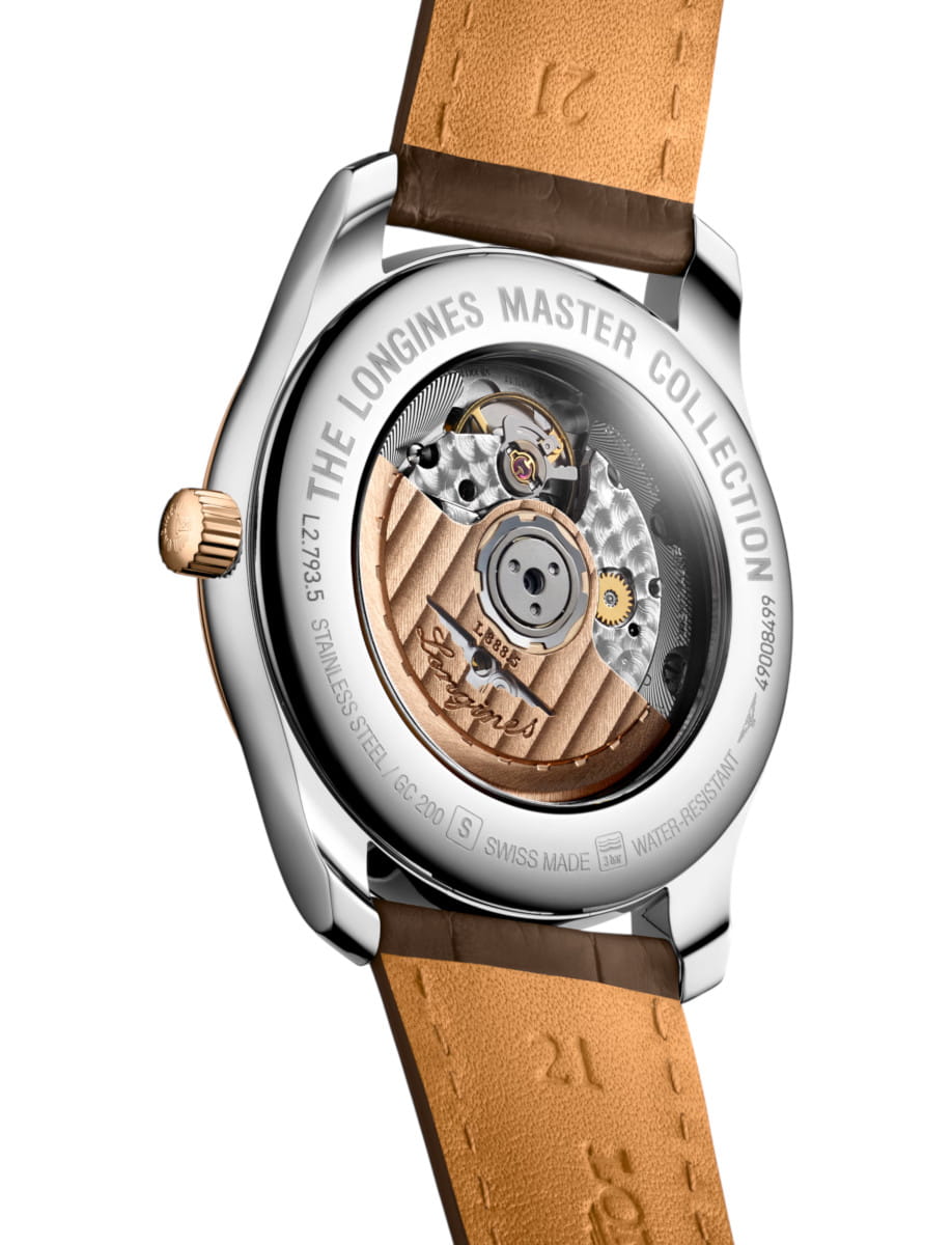 Stainless steel watch back with a transparent window showing the gold rotor and gears, brown leather strap visible at top and bottom.