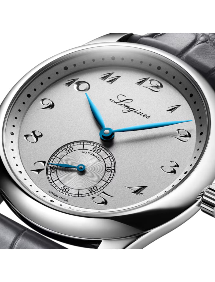 Close-up of a silver Longines wristwatch with blue hour and minute hands and a small seconds subdial at 6 o'clock