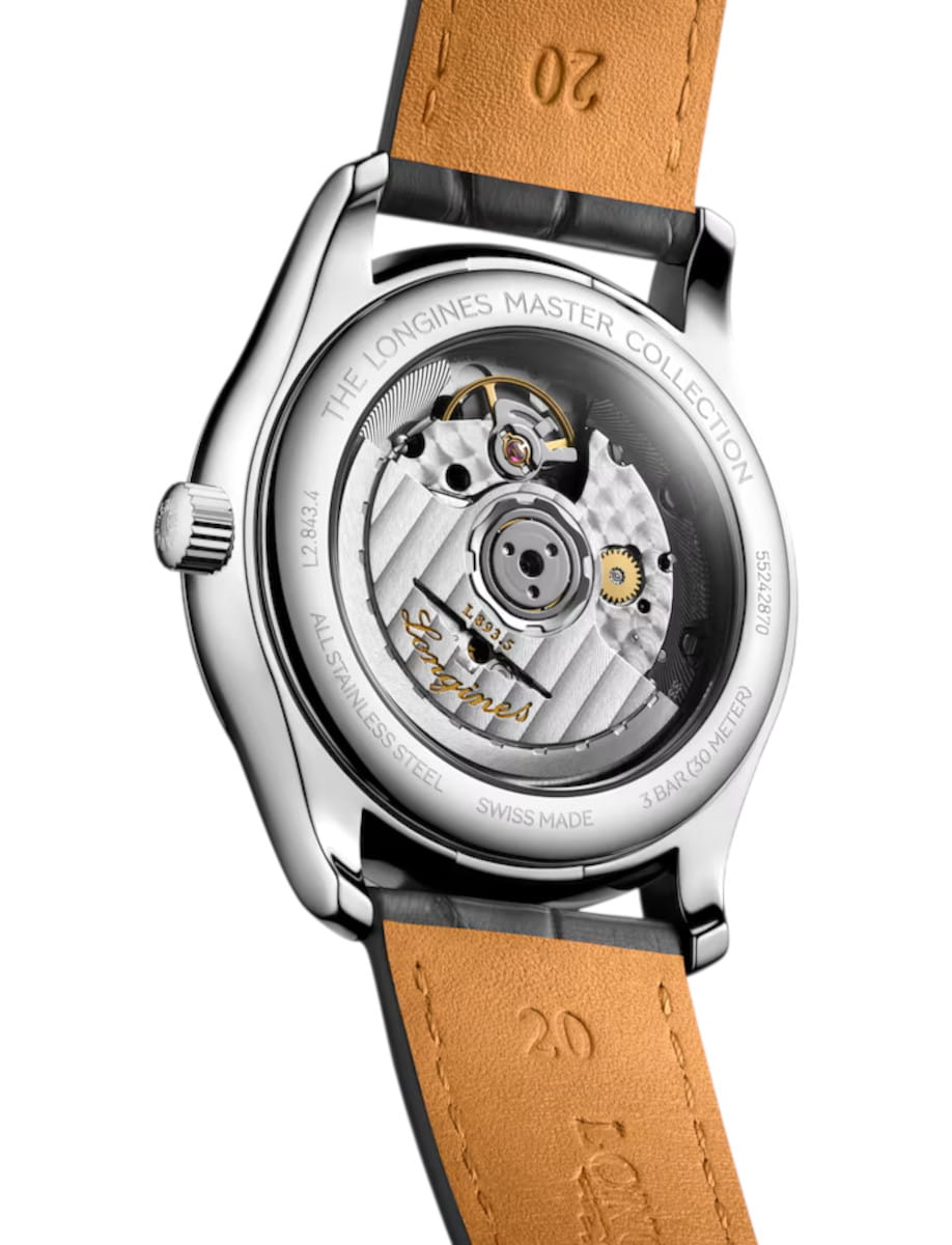 Back of a stainless steel Longines Master Collection wristwatch showing the exposed mechanical movement through a transparent case back, with a tan leather strap embossed with numbers.