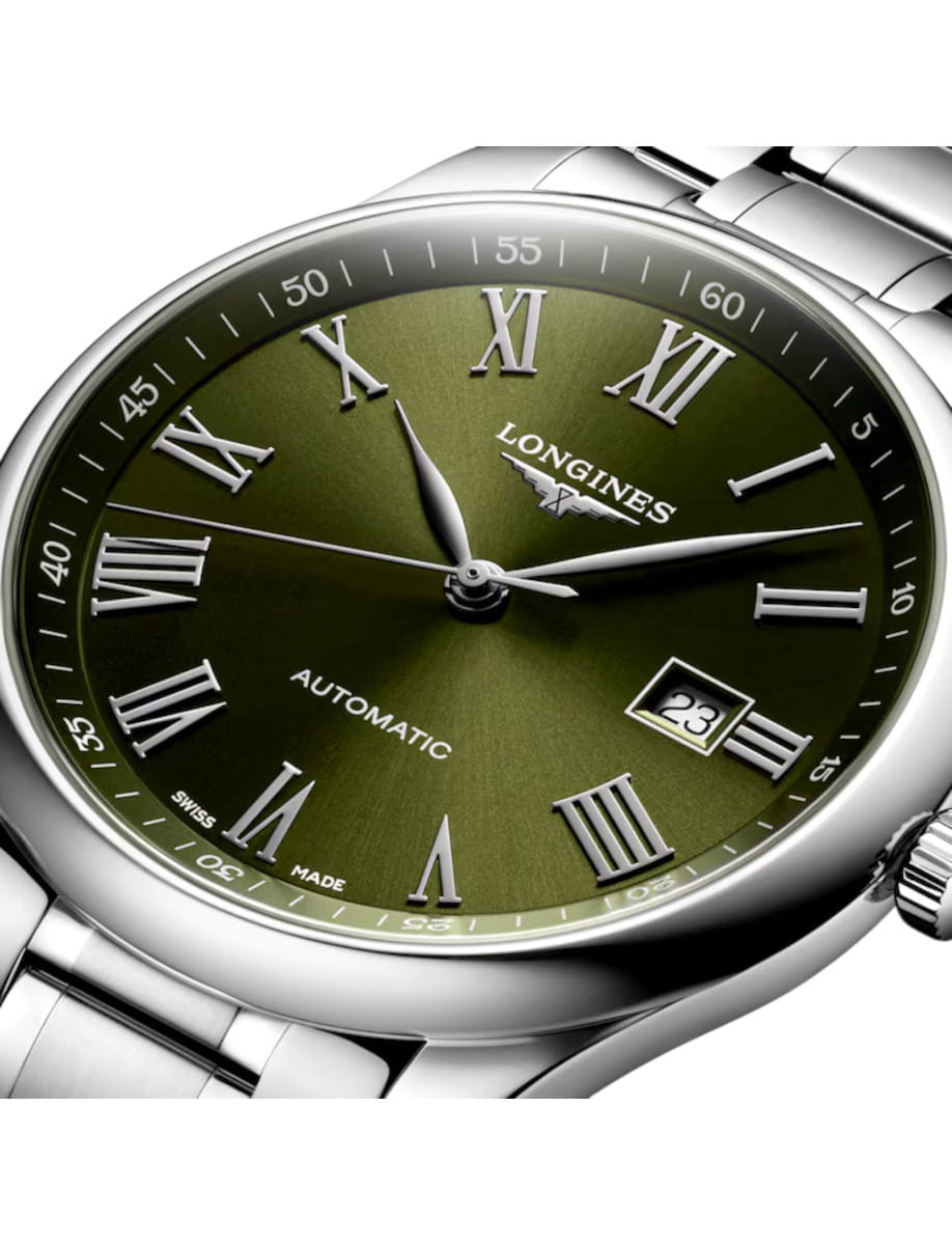 Close-up of a Longines automatic wristwatch with a green dial, silver Roman numerals, and a date window at 3 o'clock.