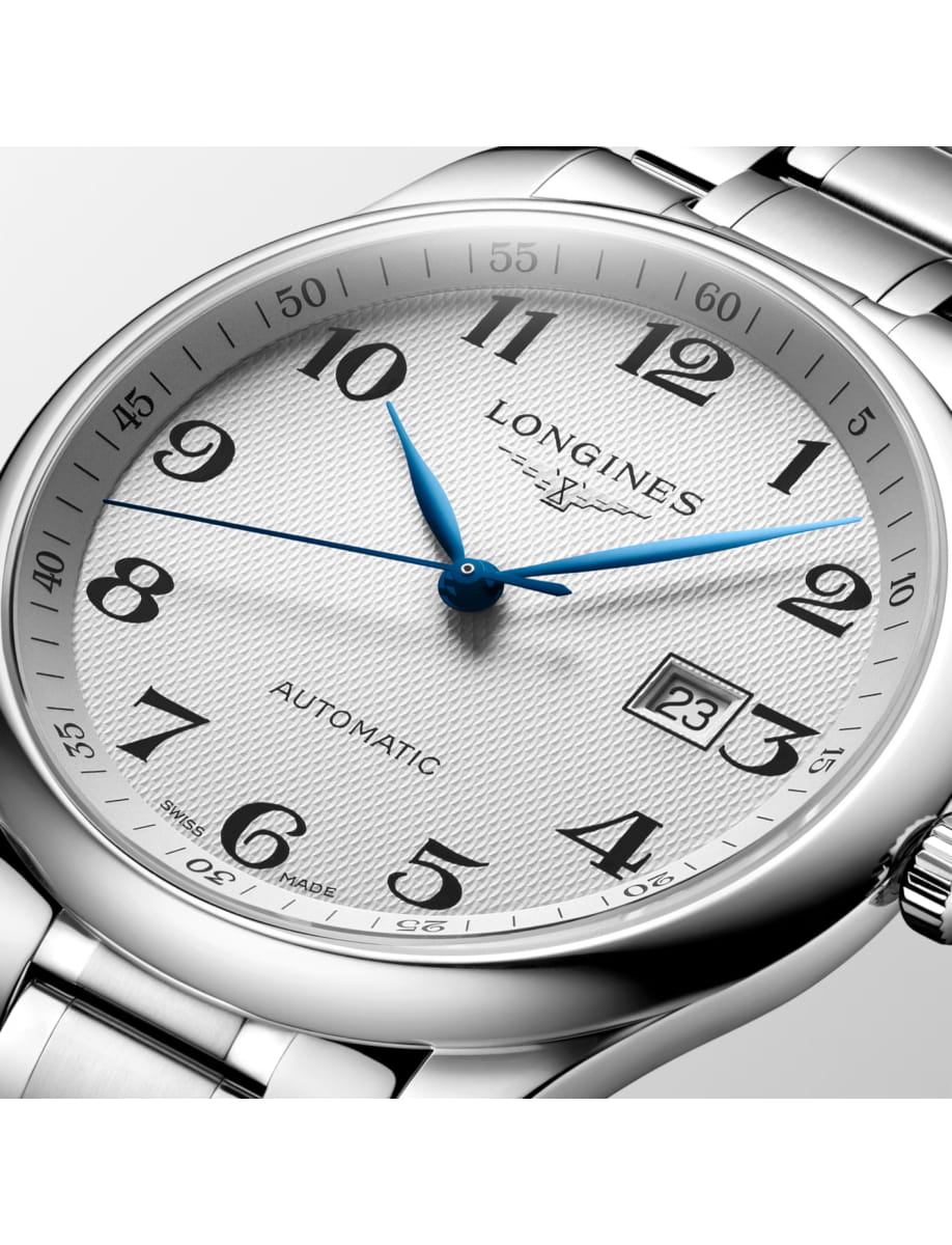 Close-up of a silver Longines wristwatch with blue hands and a date window