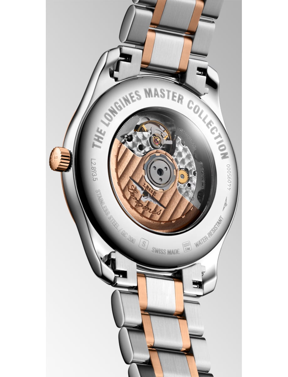 Back view of a two-tone Longines Master Collection wristwatch with exposed movement visible through a round case; the rim reads 'THE LONGINES MASTER COLLECTION'.