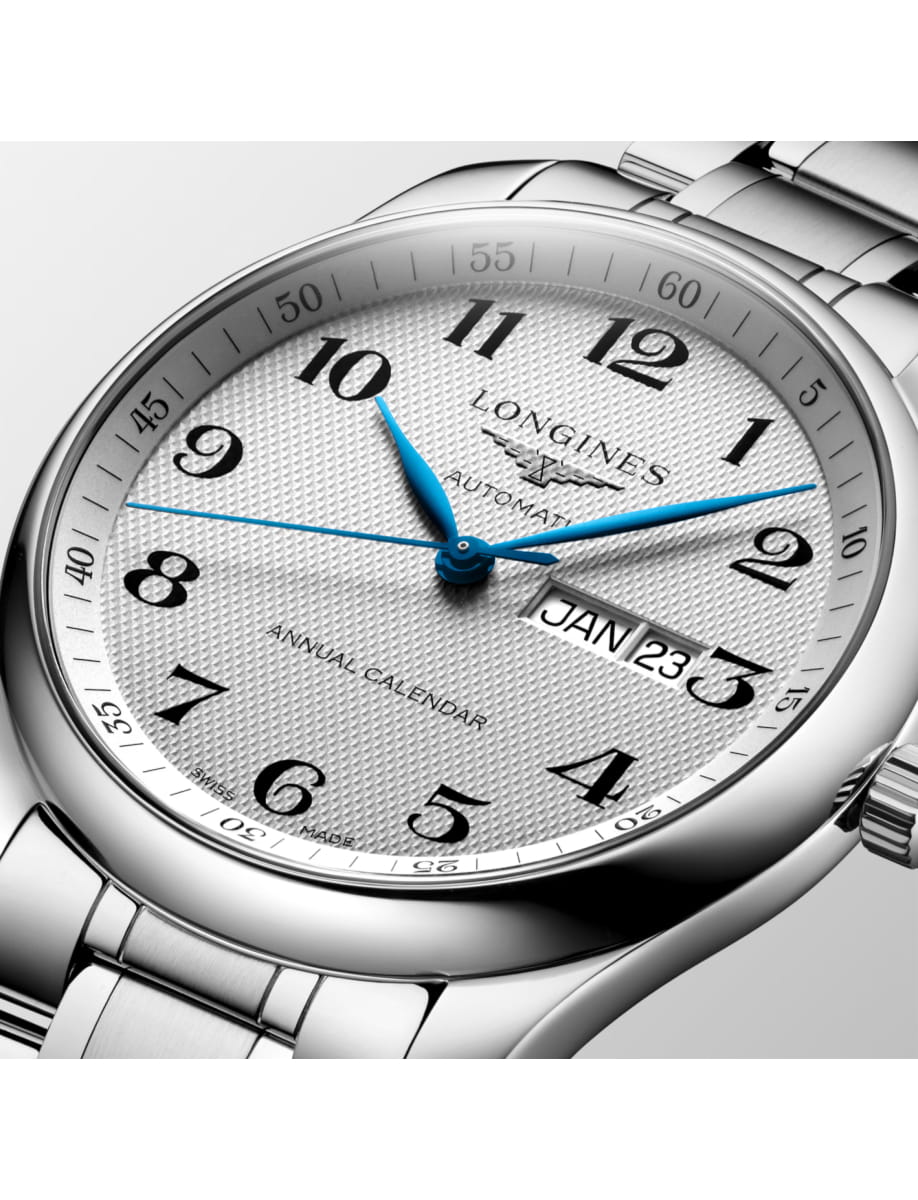 Close-up of a silver Longines automatic wristwatch with blue hands and a date window