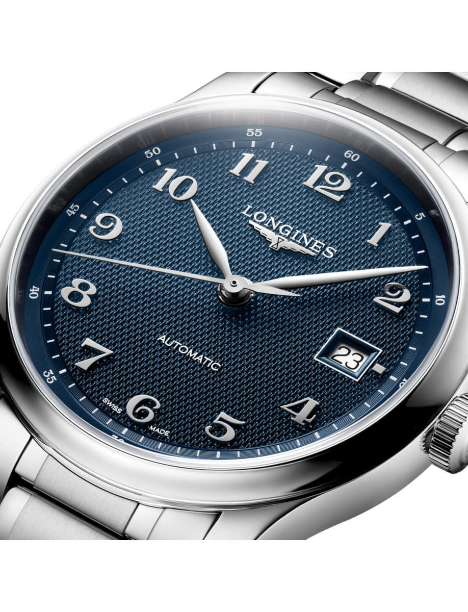 Close-up of a Longines automatic wristwatch with a blue textured dial, silver hands, and a date window at 3 o'clock.