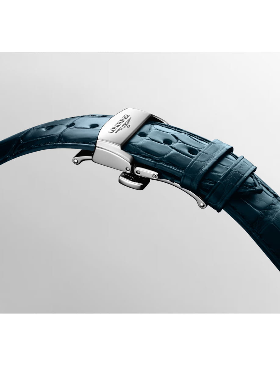 Close-up of a blue leather watch strap with a steel deployment clasp in the open position, highlighting the premium hardware