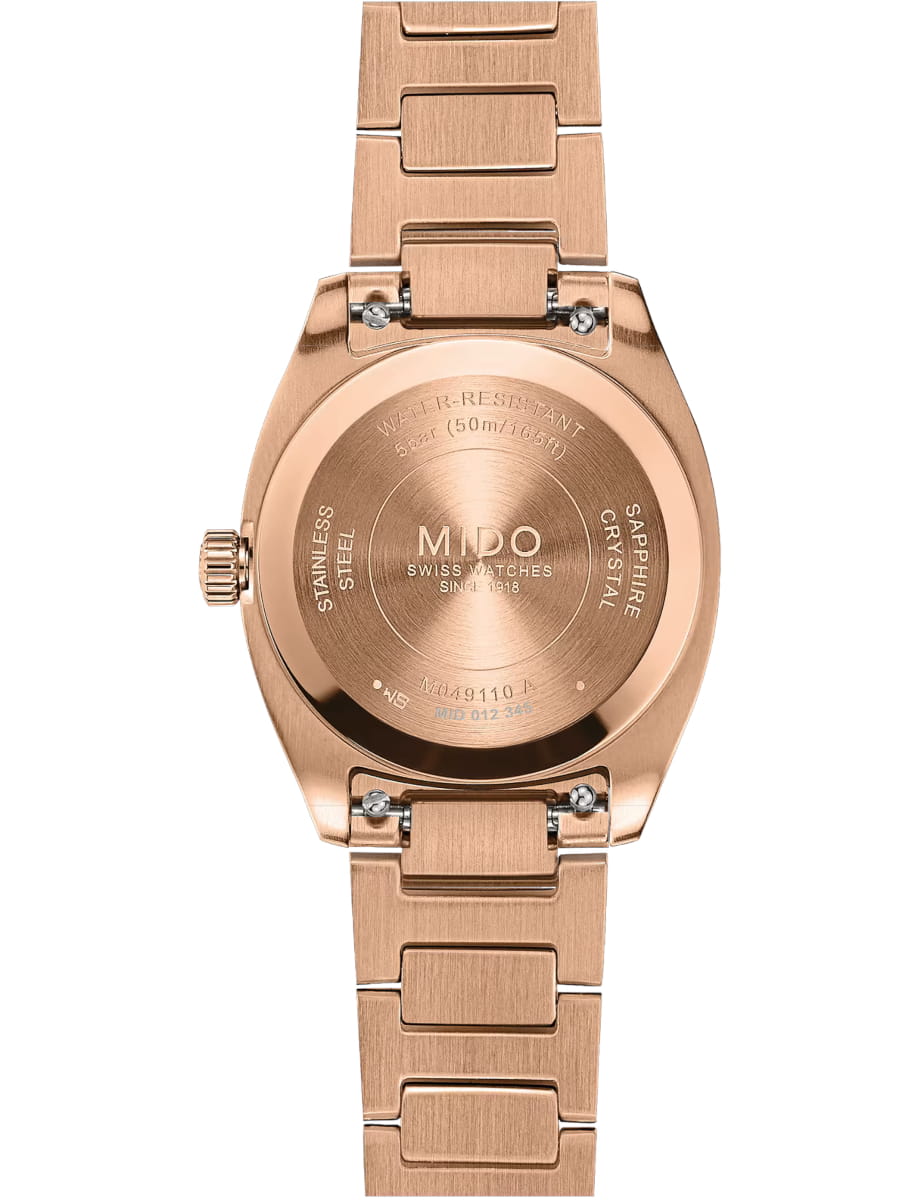 Rose-gold wristwatch back with engraved brand name 'MIDO' and metal bracelet links visible, close-up view.