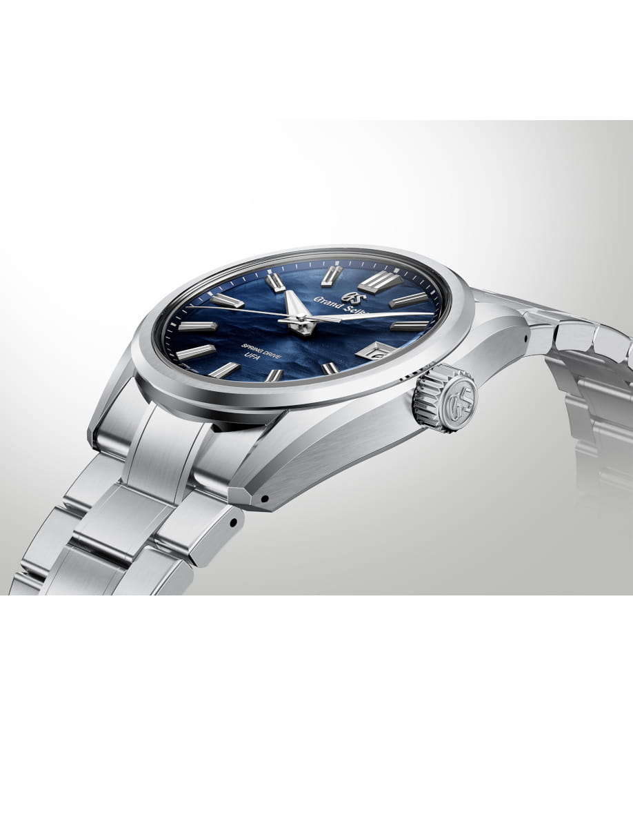Side view of Grand Seiko wristwatch with stainless steel case and bracelet, and blue dial.