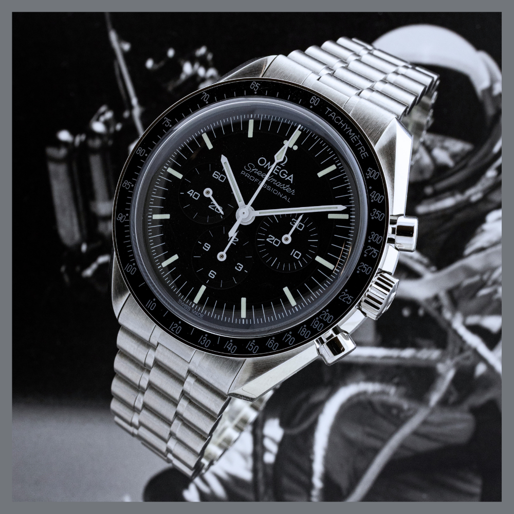 america250 2 | Feldmar Watch Co. Omega Speedmaster chronograph with black dial and tachymeter bezel on stainless steel bracelet.