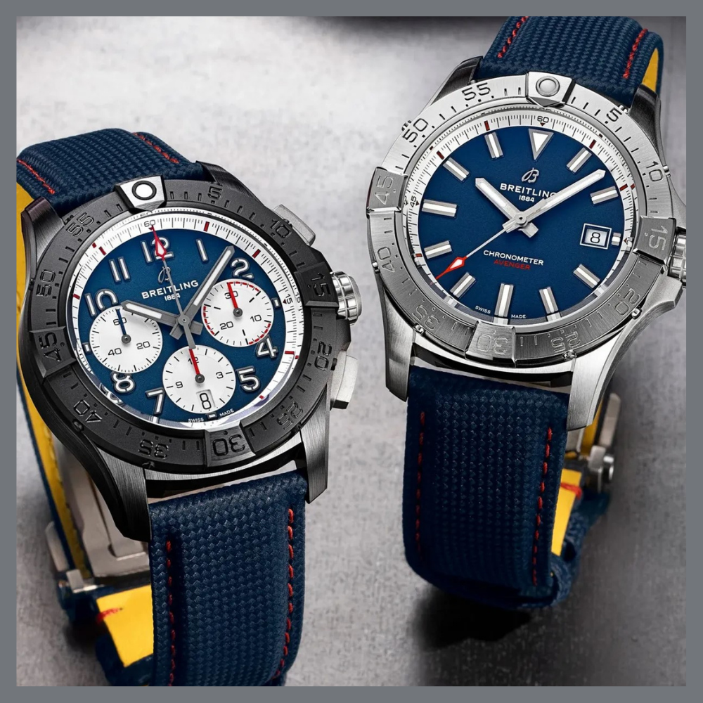 america250 3 | Feldmar Watch Co. Two Breitling watches with blue dials and blue fabric straps displayed on a gray surface.
