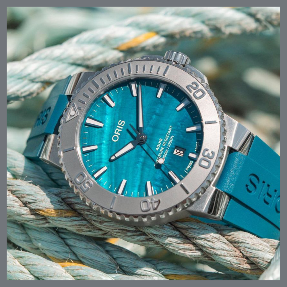 america250 4 | Feldmar Watch Co. Blue dial Oris dive watch with a silver bezel resting on thick nautical rope, teal strap visible on the side.