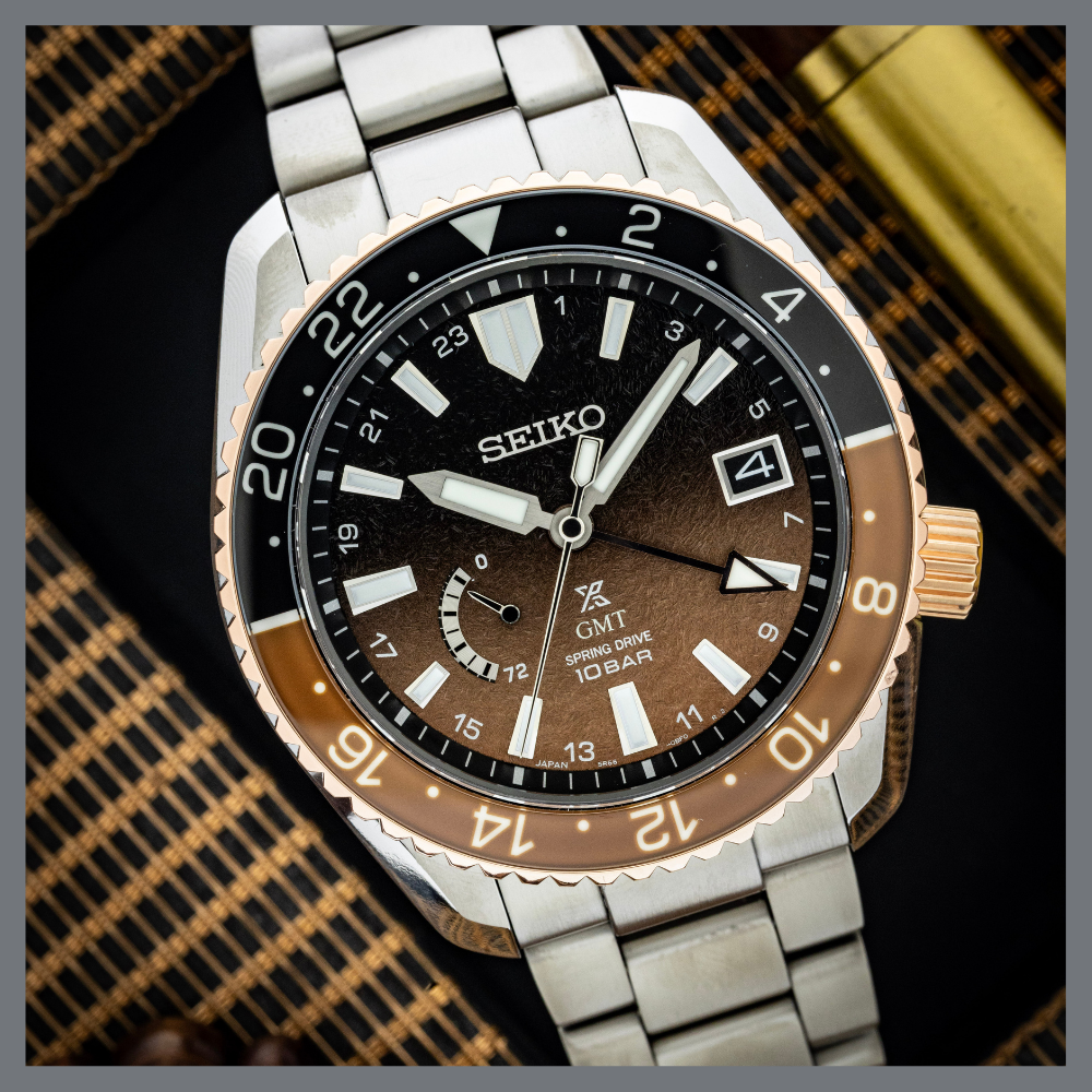 america250 5 | Feldmar Watch Co. Close-up of a Seiko GMT wristwatch with a two-tone bronze bezel and stainless steel bracelet, showing date at 3 o'clock.