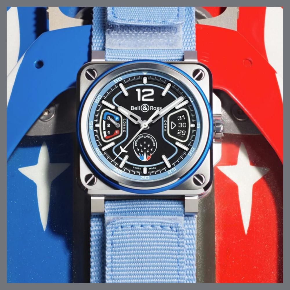 america250 7 | Feldmar Watch Co. Close-up of a Bell & Ross square-faced wristwatch with a blue strap on a patriotic red, white, and blue background