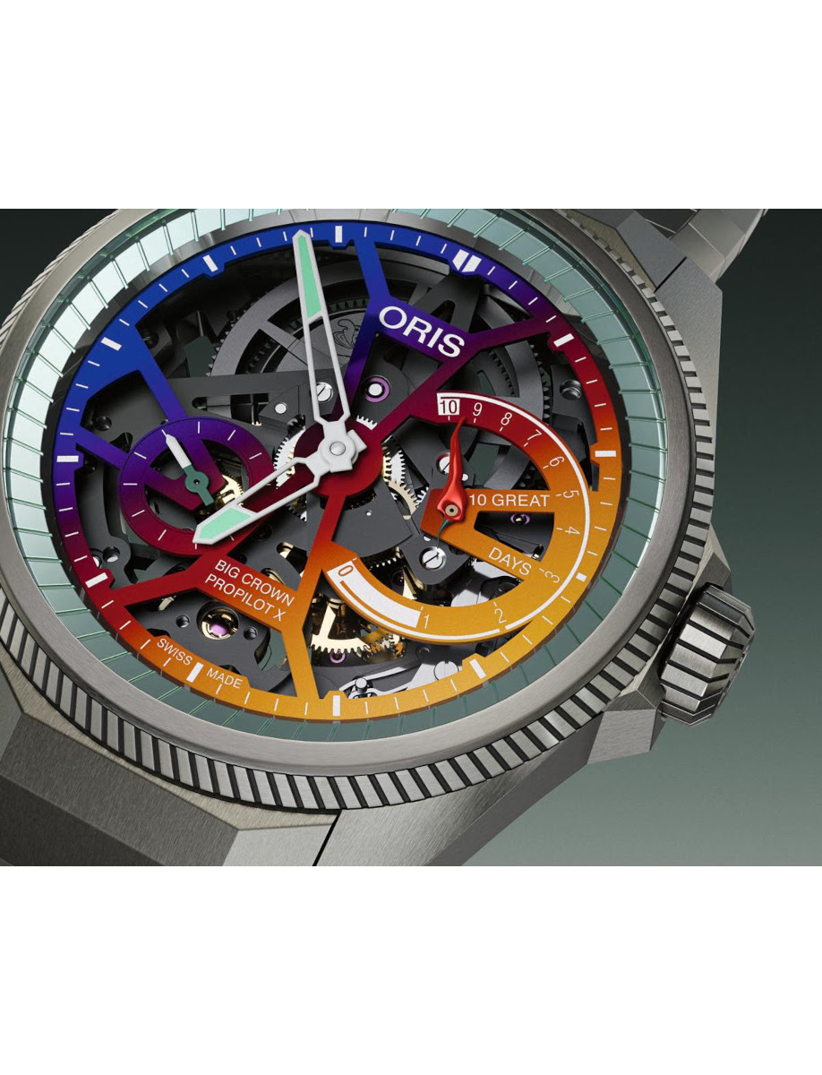 Close-up of a skeleton watch with rainbow-colored gears and hands, ORIS branding, showing the exposed movement.