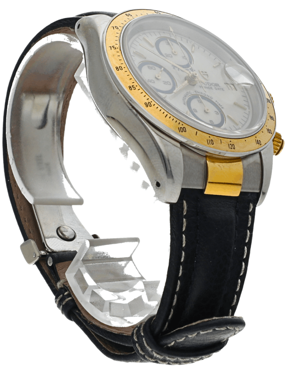 Close-up of a silver and gold chronograph wristwatch with a black leather strap and white dial