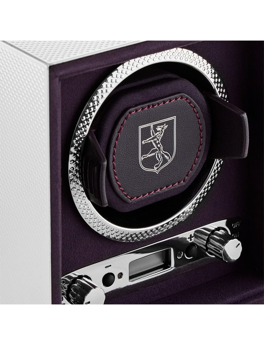 Close-up of a premium safe lock: chrome circular dial, purple interior, and a shield emblem on a padded panel.