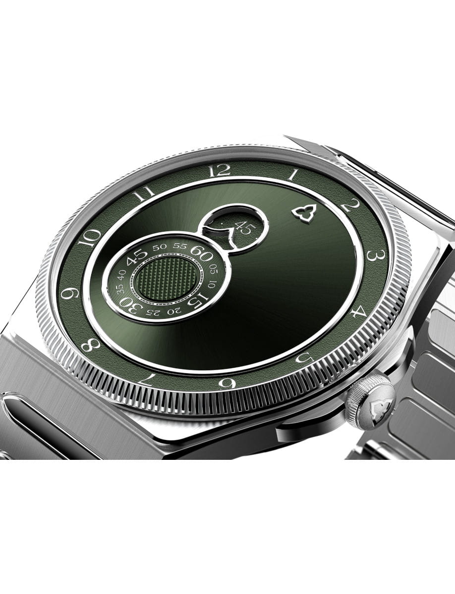 Close-up of a silver wristwatch with a green textured dial and concentric time rings showing hours and minutes