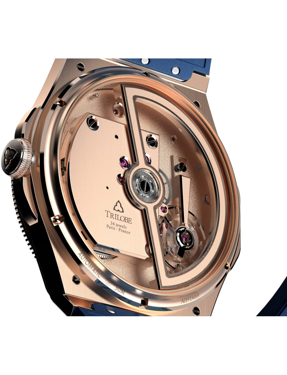 Rose-gold mechanical watch movement with exposed gears and rotor, showing 34 jewels and 'TRILOBE' branding, Paris, France