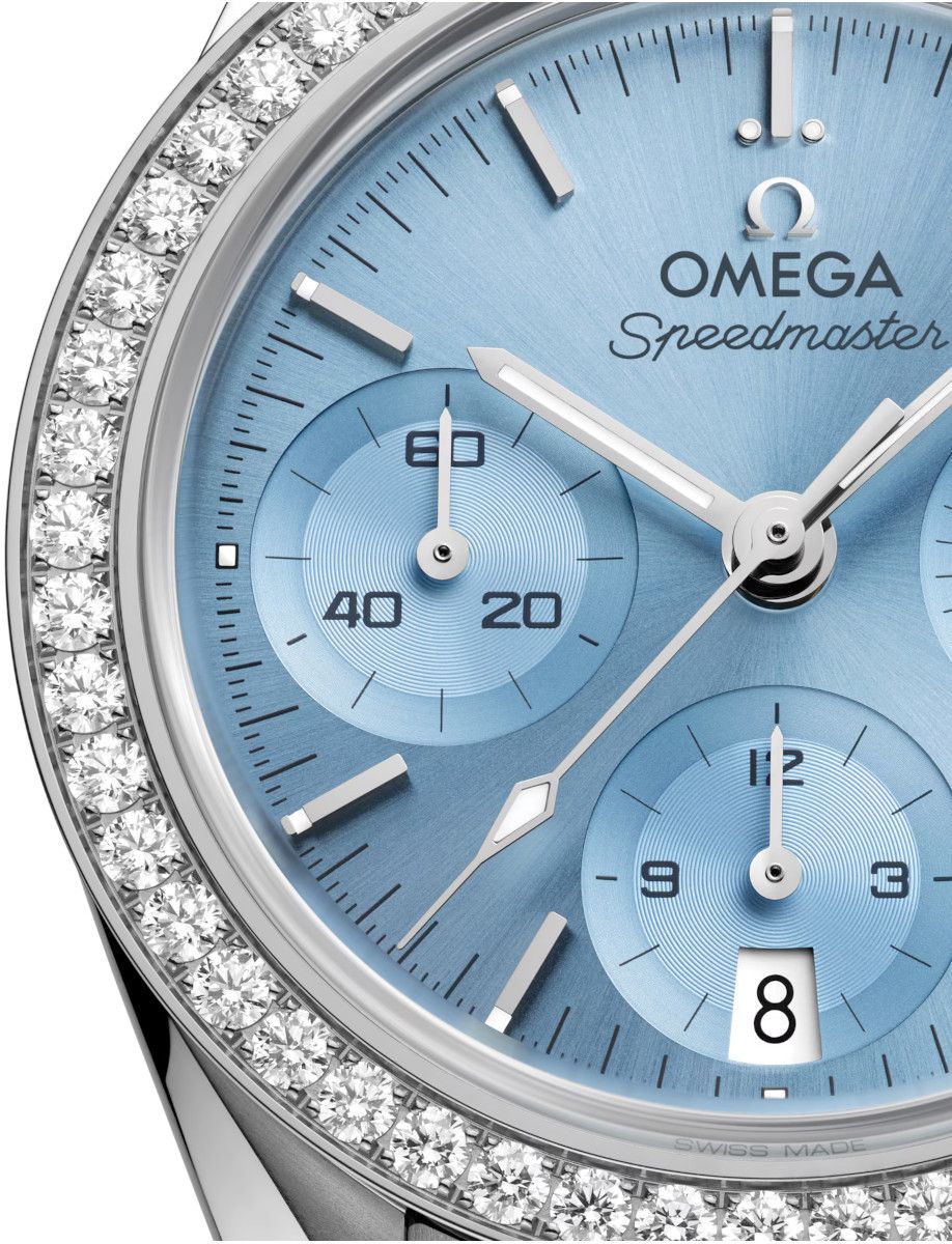 Close-up of an Omega Speedmaster watch with a blue dial and a diamond-studded bezel.