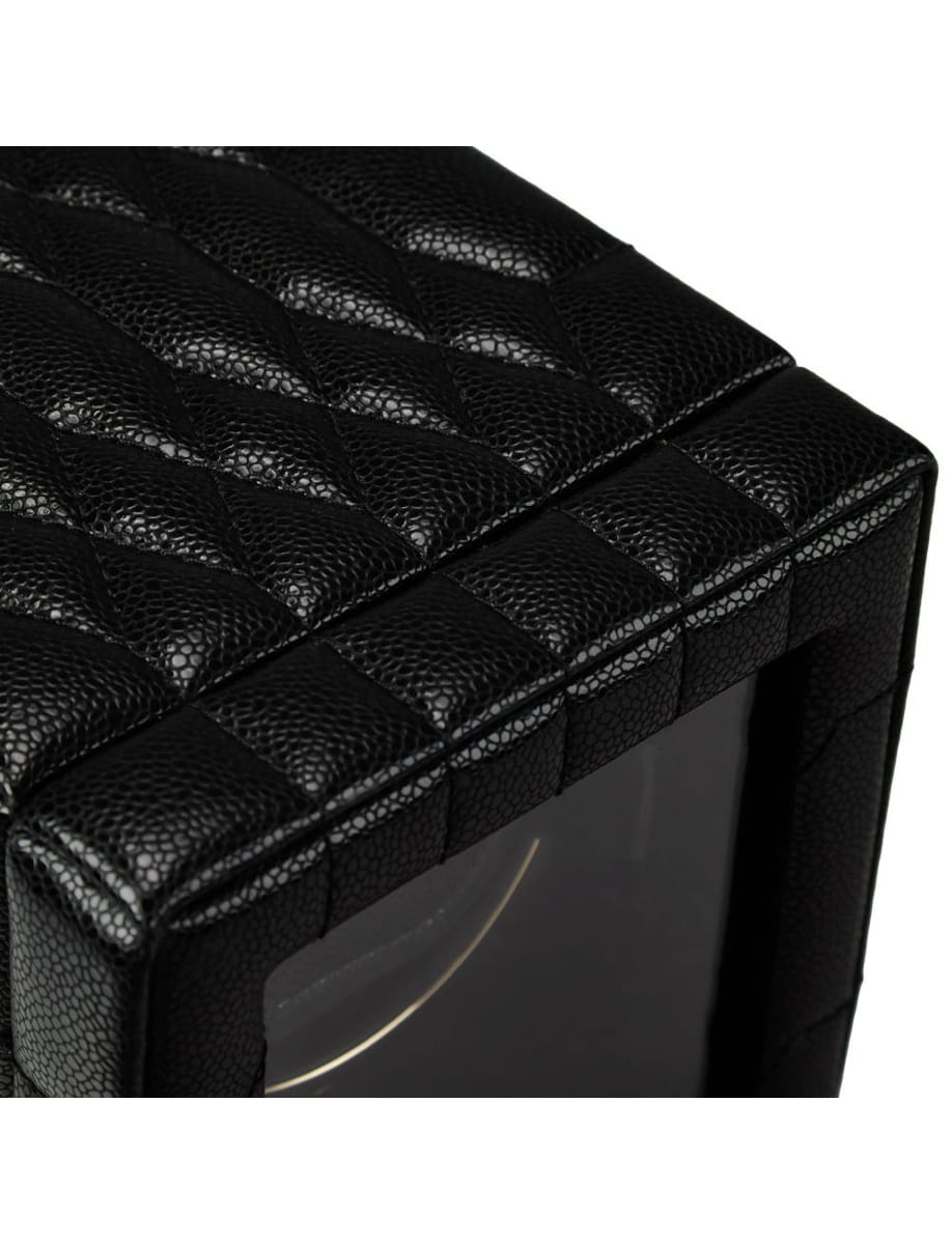 Close-up of a black quilted leather case around a device with a rounded screen, showing textured stitching.