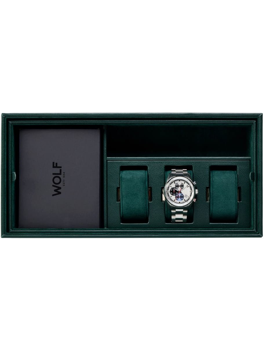 Green presentation box with a silver wristwatch centered between two green cushions and a WOLF card on the left.
