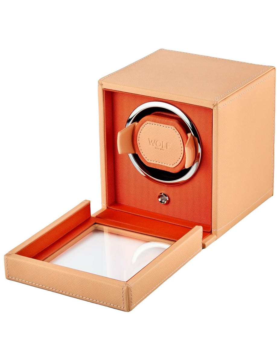 Orange over-ear headphones displayed in a matching orange presentation box with a clear lid.