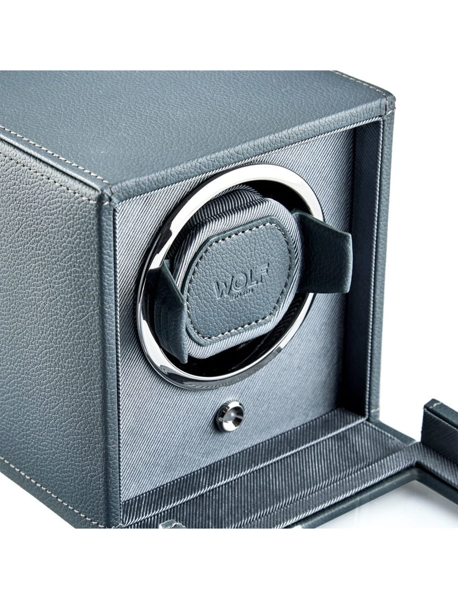 Close-up of a blue-textured safe with a circular chrome lock and padded interior, lid open.
