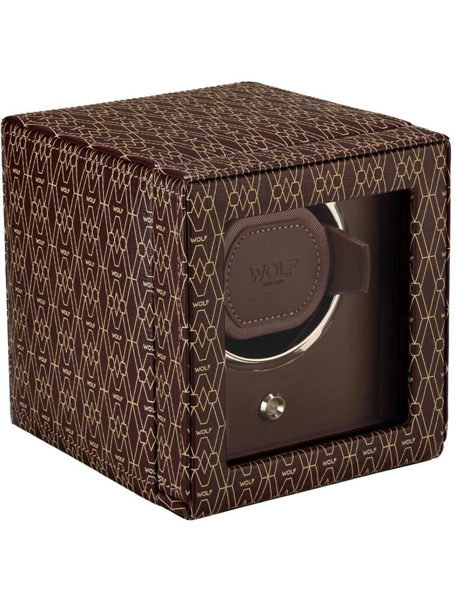 Brown Wolf watch winder inside a patterned brown box with a glass front window showing the winding mechanism.