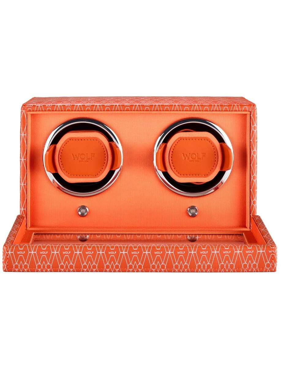 Orange over-ear headphones in a matching orange patterned display box, showcasing chrome rims around the ear cups.
