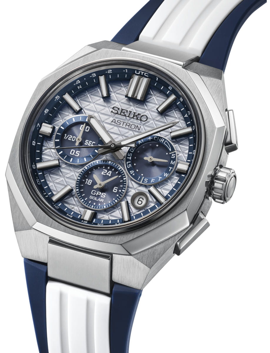 Seiko Astron titanium watch with light silver dial, multiple subdials, and a blue-and-white silicone strap.