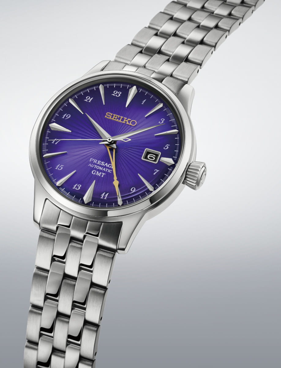 Stainless steel Seiko Presage GMT wristwatch with a vibrant purple dial and date window at 3 o'clock.