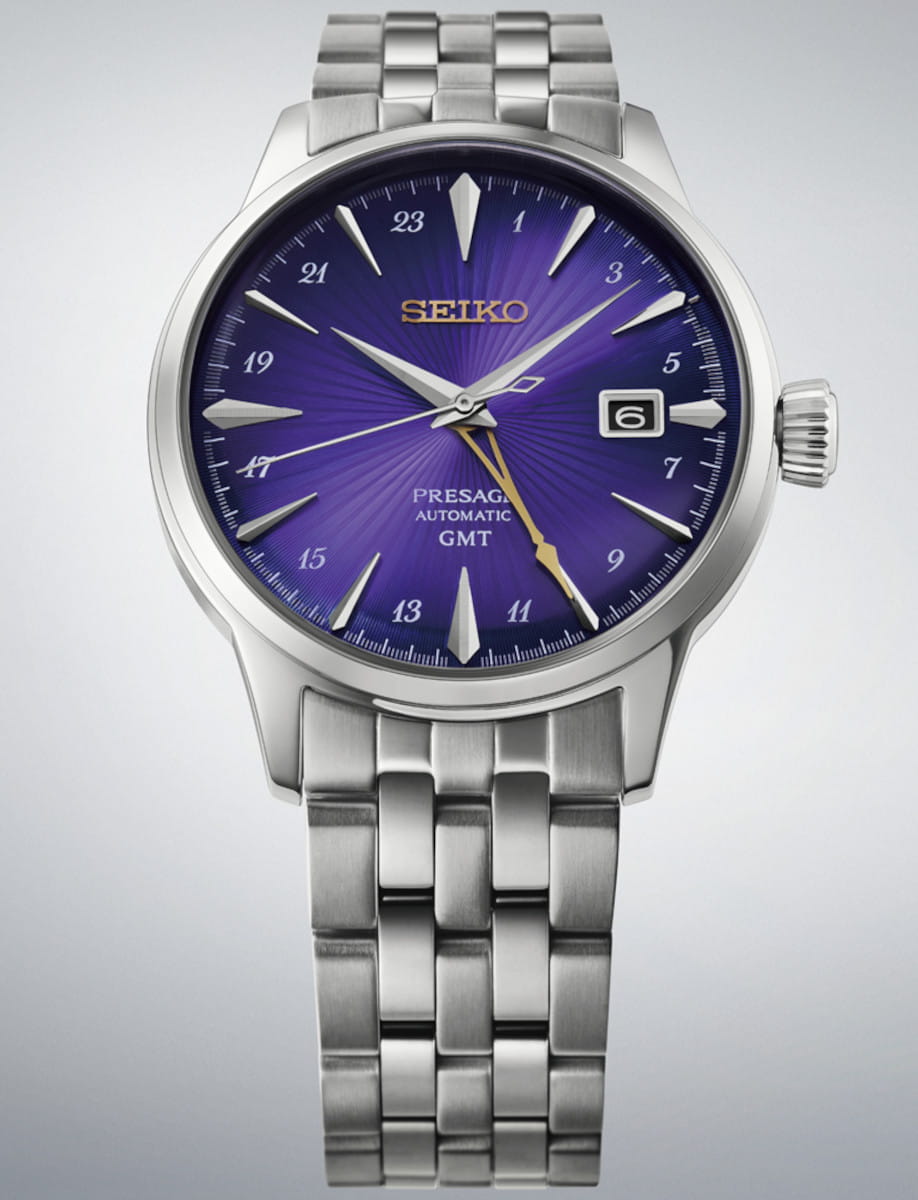 Seiko Presage automatic GMT wristwatch with a purple dial and silver metal bracelet, date window at 3 o'clock.