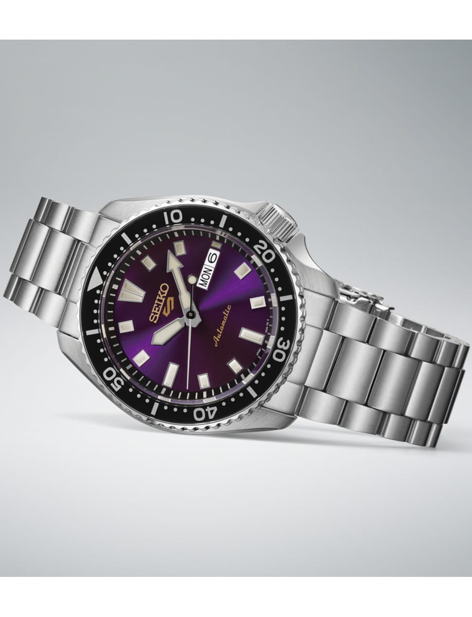 Stainless steel Seiko dive watch with a purple dial and black numbered bezel, day/date window visible on the right side.