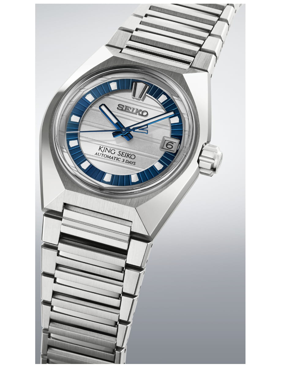 Stainless steel King Seiko wristwatch with blue-tinted dial and date window, shown at an angle with a metallic bracelet