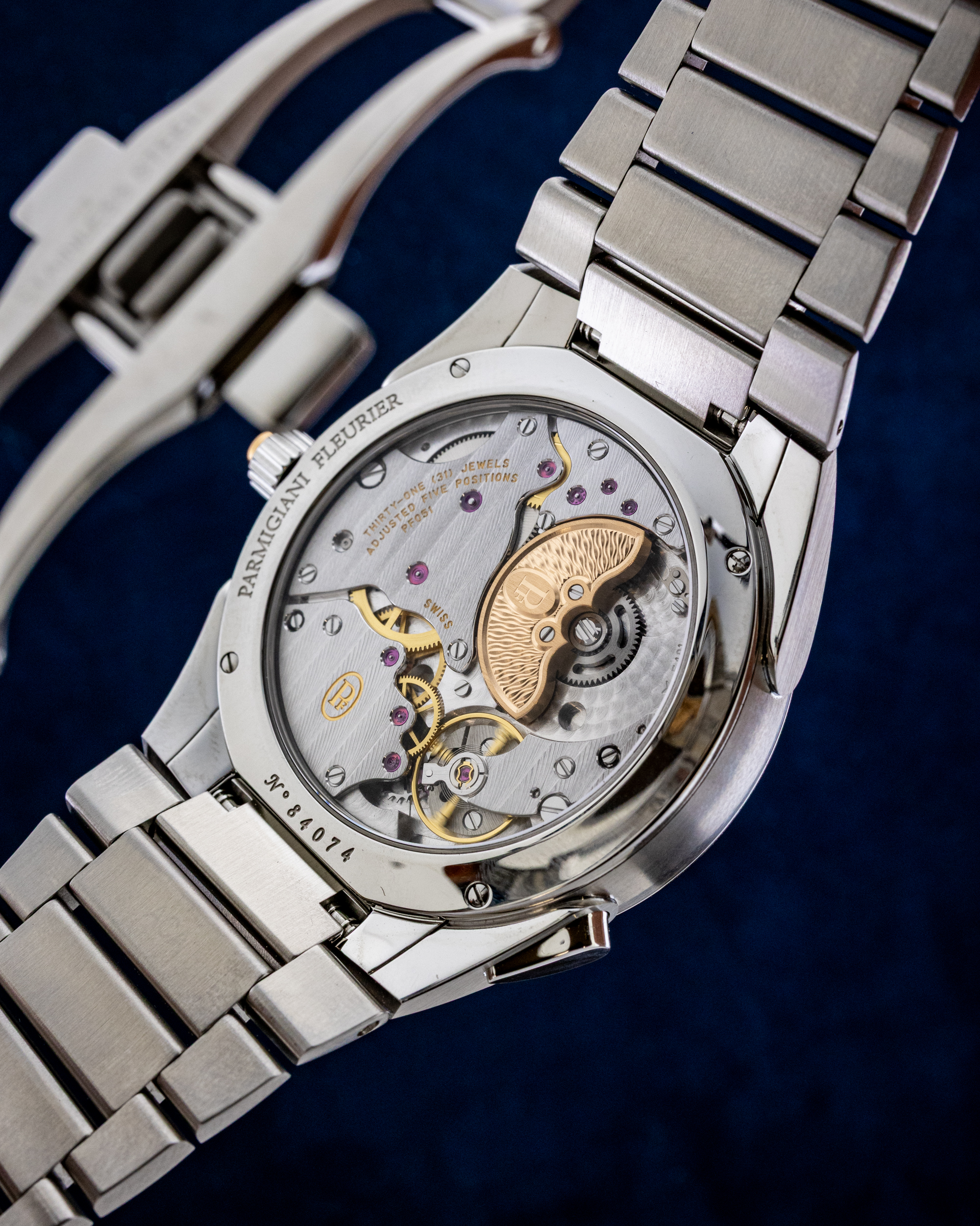 Close-up of a stainless steel watch showing its transparent back and intricate mechanical movement with gears and jewels visible