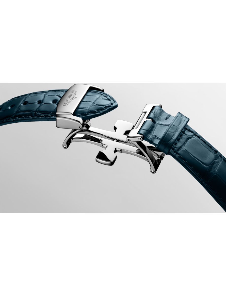 Close-up of a blue alligator-embossed leather belt with a silver interlocking buckle.