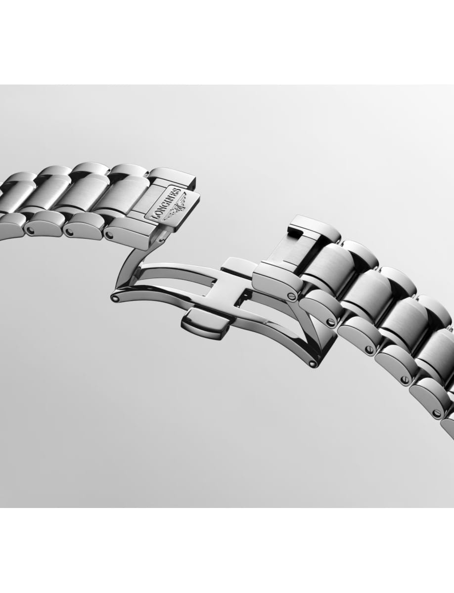 Close-up of a silver metal watch bracelet with a deployment clasp, Longines engraving visible on the clasp.