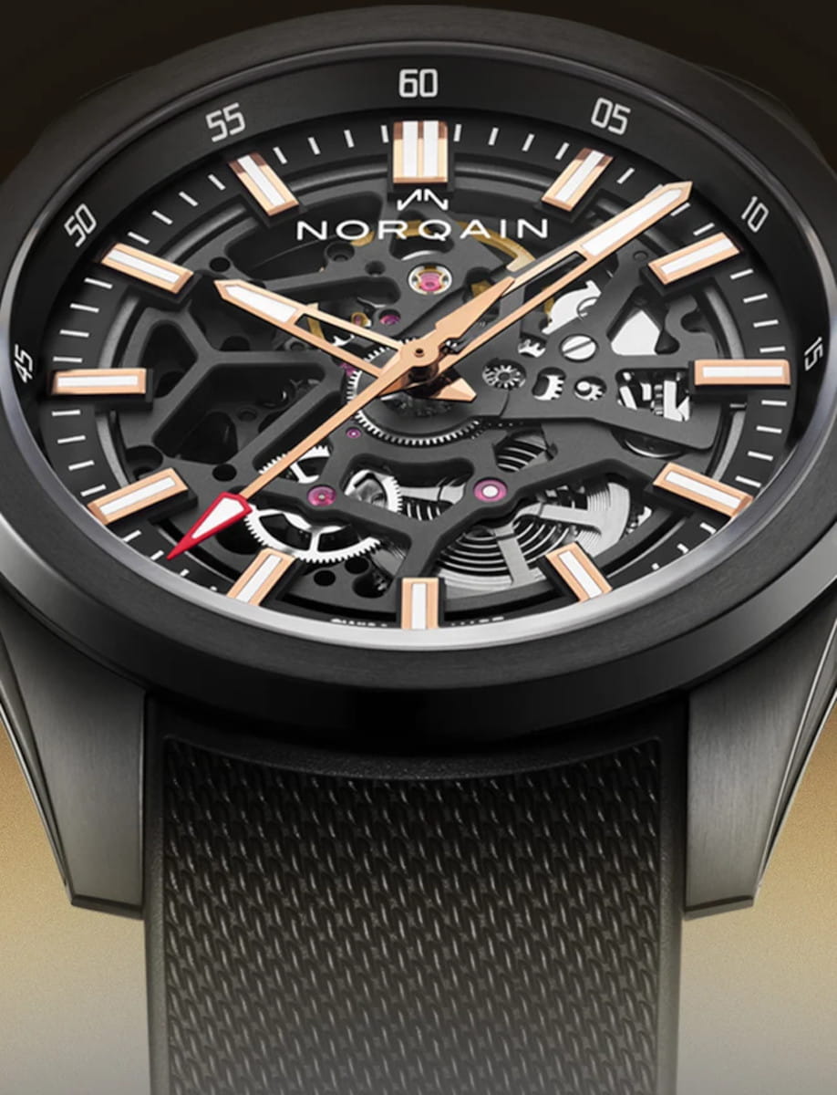 Skeleton watch with exposed gears and rose-gold hands, Norqain logo visible on dial, black bracelet.