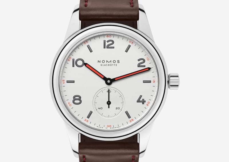Nomos Glashütte wristwatch with white dial, black numerals, red-accent hour and minute hands, small seconds subdial, and brown leather strap.